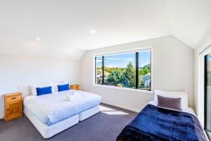 特卡波湖山景度假屋的一间卧室设有两张床和窗户。
