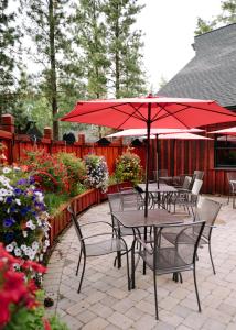 姊妹城五柏旅舍的一个带桌椅和红色遮阳伞的庭院