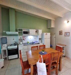 普洛缇尔Casas Noviembre的一间带木桌和椅子的厨房和一间带炉灶的厨房