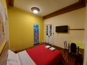 阿雷基帕Holidays Hostel Arequipa的一间卧室配有红色的床和电视