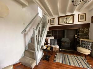 瑟勒斯Maggie's Cottage的一间带楼梯和壁炉的客厅