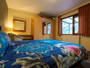 乌登Villa Maashorst的一间卧室配有一张带蓝色毯子和鲜花的床