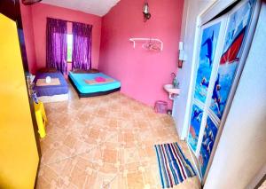 瓜拉勿述Rumah Hentian Ayah的客房设有两张床和一间带粉红色墙壁的浴室