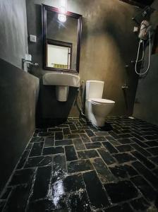 尼甘布克尚度假屋的一间带卫生间、水槽和镜子的浴室