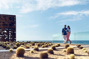 圣何塞德尔卡沃Zadún, a Ritz-Carlton Reserve的海滩上行走的男人和女人
