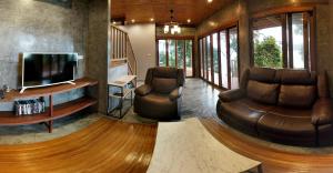 丽贝岛Cashewnut Cove的客厅配有2把皮椅和电视