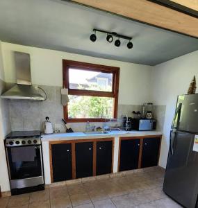 拉安戈斯图拉镇Casa AICU的厨房配有水槽、炉灶和窗户。