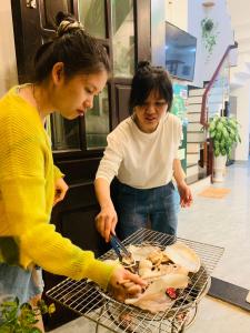 会安GIA THÀNH HOMESTAY的两个女人在烧烤架上做饭