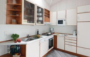 特拉弗明德Strandblick 7 - Dorf 1的厨房配有白色橱柜和水槽