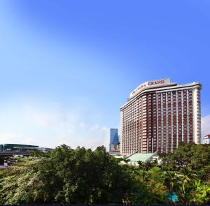 曼谷盛泰澜曼谷拉普崂中央广场酒店的一座高大的建筑,上面有桑坦德标志