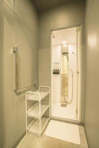 福冈Hostel STAND BY ME的带淋浴和毛巾架的浴室