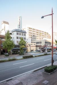 福冈Hostel STAND BY ME的城市中一条空荡荡的街道,有高大的建筑