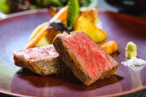 神户阿里马萨恩索夫格索贝烁酒店的紫色盘子,有两块肉和蔬菜