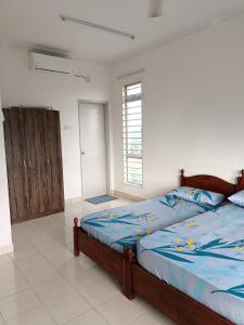 普特拉贾亚Jannah Homestay Seruling的一间卧室配有一张带蓝色棉被的床