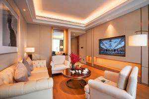 杭州杭州华盛达雷迪森广场酒店的客厅配有白色家具和电视
