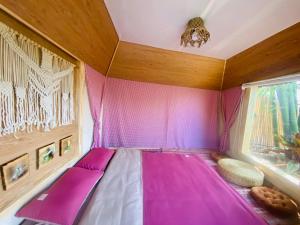 大叻Hoàng Gia Trang的客房设有粉红色的床和窗户。