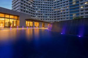 杭州杭州华盛达雷迪森广场酒店的一座大型建筑,前面设有一个游泳池