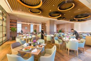杭州杭州华盛达雷迪森广场酒店的一间设有桌椅的餐厅,里面有人