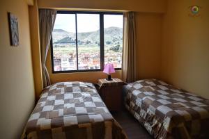 科帕卡巴纳solsticio hostel的带大窗户的客房内的两张床