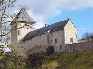 Peyrat-le-ChâteauChambres d'Hôtes L'Hirondelle du Lac的山上一座大型石头建筑