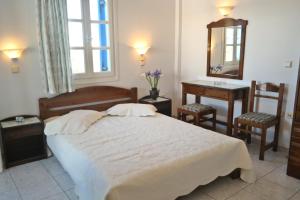 阿吉奥斯普罗科皮奥斯Mina's Studios in Naxos Island的一间卧室配有一张床、一张桌子和一面镜子