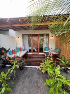 迪古拉Seaside Dhigurah的房屋设有带椅子和植物的庭院
