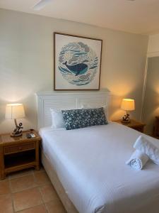 扬巴克维亚巴酒店的一间卧室配有白色床和2个床头柜