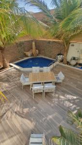 延布ريفان لبيوت الضيافة خاصة的庭院设有游泳池、桌子和椅子。