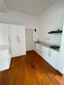 马特勒Atteriya HILLTOP的一间空厨房,配有白色的橱柜和木地板