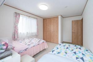 川口市Travel Palace Miyuki "Yomiuri Shimbun" - Vacation STAY 10239的一间卧室设有两张床和窗户。
