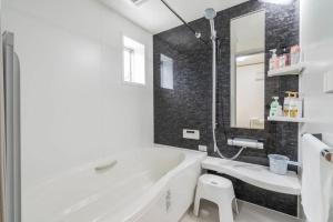 川口市Travel Palace Miyuki "Yomiuri Shimbun" - Vacation STAY 10239的白色的浴室设有浴缸和水槽。