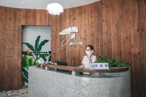 富国JM Boutique Hotel的坐在一张桌子上的手提电脑的女人