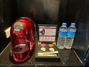 台北安庭台北商旅的两瓶水旁边的红色烤面包机