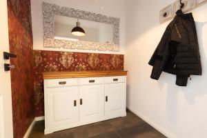 奥斯赛拜-塞林Ferienhaus Hus Oetti的一间带白色橱柜和镜子的浴室