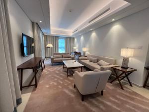 富查伊拉Address Beach Resort Residence Fujairah的带沙发和椅子的客厅以及电视