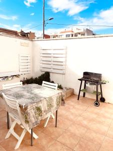 代尔特布雷El Nido: Una casita de ensueño的露台上的桌椅,烧烤架