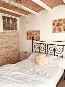 代尔特布雷El Nido: Una casita de ensueño的卧室内的白色床,设有砖墙