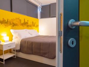 米兰Blocco Sauli的一间卧室设有一张床和黄色的墙壁