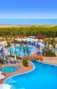 卡内拉岛Playamarina的享有带椅子和遮阳伞的度假村游泳池的空中景致