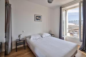 塞纳河畔伊夫里Cosy Residence Paris Sud的卧室设有白色的床和大窗户