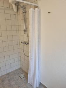 维泽桑讷Feriehuse Hvide Sande的浴室内配有白色淋浴帘。