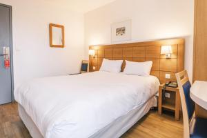 斯特拉斯堡Hotel Strasbourg - Montagne Verte & Restaurant Louisiane的卧室配有一张白色大床和木制床头板