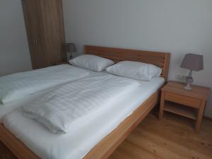 巴德米滕多夫Ferienwohnung Salzafeld的一张带两个白色枕头和床头柜的床
