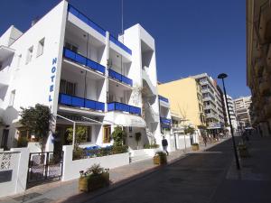 马贝拉芬兰蒂亚酒店的白色的建筑,设有蓝色的阳台,位于街道上