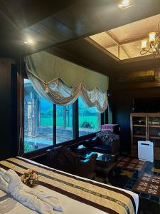 湄林班顿洛度假村 的一间卧室设有一张床和一个大窗户