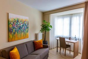沙夫豪森克罗嫩霍夫酒店的客厅配有沙发和带绘画的桌子