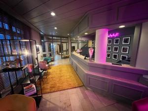 布伦瑞克Das Seela Braunschweig的餐厅设有酒吧,拥有紫色的墙壁和椅子