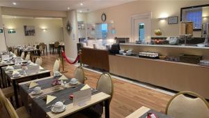 滨海韦斯顿皇家格罗夫纳酒店的一间带桌椅和柜台的餐厅