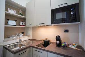 塞斯托卡伦德[Dalia Suite] Leonardo Academy, MXP & Lakes的厨房配有水槽和微波炉