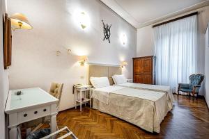 佛罗伦萨亚历山德拉酒店的配有一张床和一张书桌的酒店客房